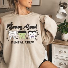 Retro Dental Halloween Sweatshirt, Funny Dental Hygienist Shirt, Halloween Dentist Shirt, Dental Office Group Shirts, Dental Assistant 🌟Welcome to CardaCreationsCo🌟 ✅ITEM DESCRIPTION✅ Garment Types & Features 💞Gildan Crewneck 1800 Unisex Heavy Blend Crewneck Sweatshirt💞 Medium-heavy fabric (8.0 oz/yd² (271.25 g/m Loose fit Runs true to size 50% cotton, 50% polyester Sewn-in label 💞Bella & Canvas 3001 Unisex Jersey Short Sleeve Shirt💞   100% Airlume combed and ringspun cotton (fiber content Dental Halloween Shirt, Dental Hygiene Shirt, Dental Halloween, Dental Shirts, Group Shirts, Dental Hygienist, Dental Assistant, Dental Office, Halloween Sweatshirt