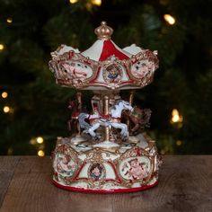 a merry go round on a wooden table in front of a christmas tree