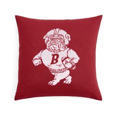 a red pillow with an image of a bulldog holding a football ball in his hands