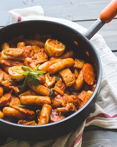 a pan filled with some kind of food on top of a table next to a napkin