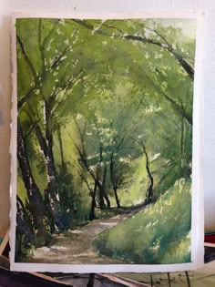 a watercolor painting of a path in the woods