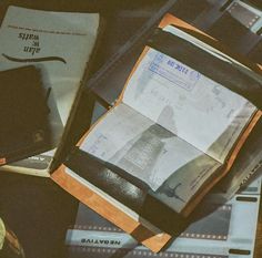 an open passport case sitting on top of a table next to other travel books and papers