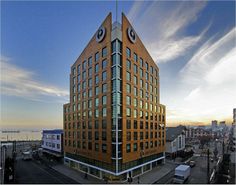 a very tall building with two clocks on it's face in the middle of a city