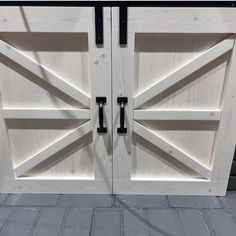 two wooden doors with black handles on them