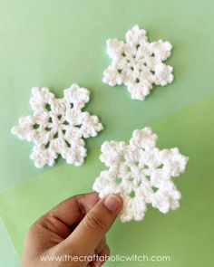 crochet snowflakes are shown in three different colors and sizes, with one being held up to the camera