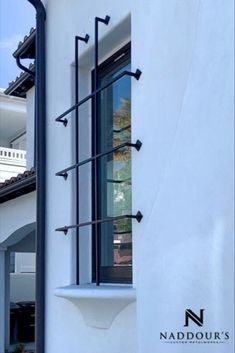 An wrought iron grill on the window of a white stucco house. Window Fence Metal Modern, Iron Frame Windows, Metal Bars For Windows, Window Guards Modern, Window Guards, Window Grill Minimalist, Security Bars For Windows, Best Grill Design For Windows