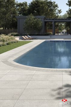 an empty swimming pool surrounded by grass and trees