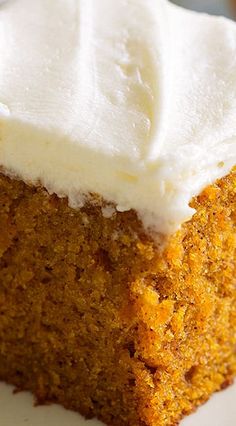 a close up of a piece of cake on a plate with cream cheese frosting