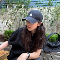 a woman sitting on a bench wearing a hat