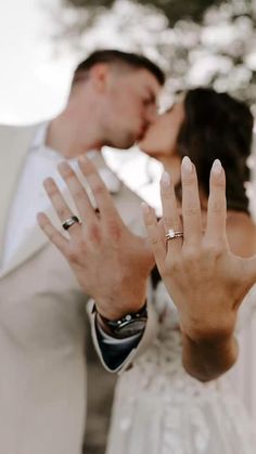 a bride and groom kissing with their hands in the air