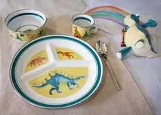 a child's meal set with dinosaur plates and spoons