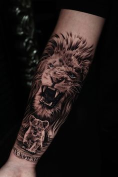 a man's arm with a lion and cub tattoo on it, while the other hand is holding his wrist