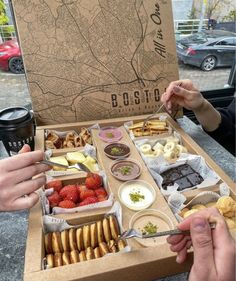 two people eating food from a box on a table with a map in the background