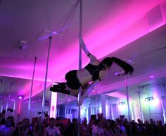 a woman is performing aerial acrobatic tricks in front of a crowd