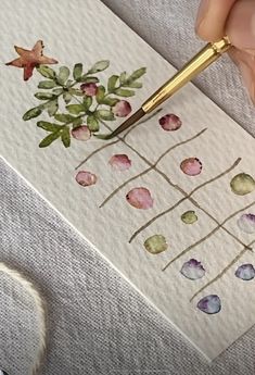 someone is painting flowers with watercolors on paper