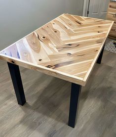 a table made out of wood and metal legs on the floor in a living room