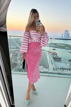 a woman taking a selfie while wearing a pink and white striped dress