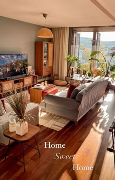 a living room filled with furniture and a flat screen tv on top of a wooden table