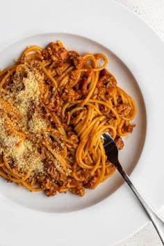 a white plate topped with spaghetti and meat