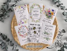 the wedding stationery is laid out in a wicker basket with flowers and greenery