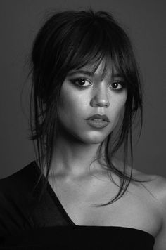 a black and white photo of a woman with long hair wearing a strapless top