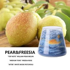 there is a blue and white vase next to two pears on a wooden table