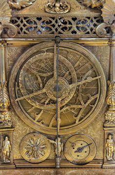 an intricately designed clock is shown in gold