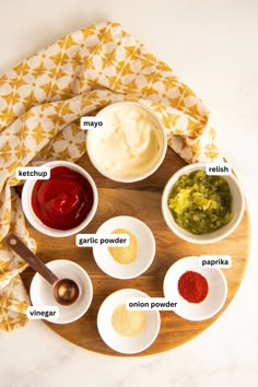 an overhead view of different condiments on a wooden platter, with the ingredients labeled