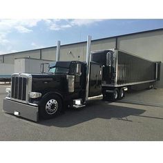 a black semi truck parked in front of a building