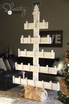 a christmas tree made out of wooden blocks in front of a living room with a couch