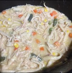 chicken noodle soup with carrots, celery and corn in a pot