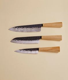 three knives with wooden handles on a table