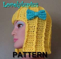 a crocheted yellow hat with a blue bow is shown on top of a mannequin head