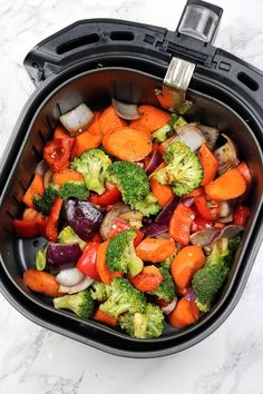 a close up of a bowl of food with broccoli and carrots in it