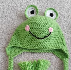 a crocheted frog hat with a pom pom