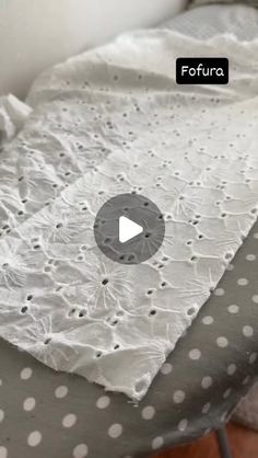 an ironing board with white polka dots on it and a video screen showing how to sew