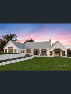 a large white house sitting on top of a lush green field