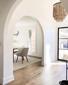 an archway leading to a dining room with a table and chairs in the corner,