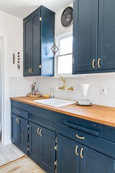 a kitchen with blue cabinets and wooden counter tops