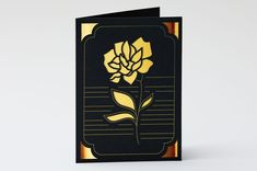 a black and gold card with a flower on it