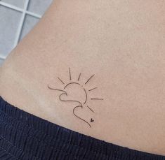 a small sun tattoo on the back of a woman's rib - up stomach