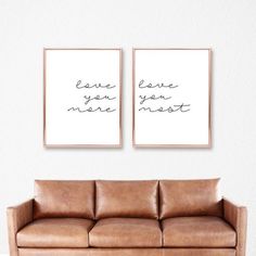 two brown leather couches sitting next to each other in front of a white wall