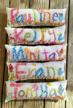 three embroidered pillows with the words happy on them