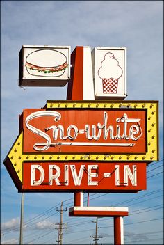 a red and yellow sign that says snow white drive - in