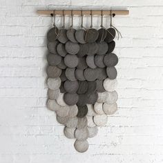 a wall hanging made out of rocks and metal hooks