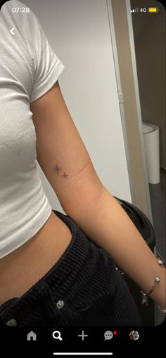 a woman's arm with a small star tattoo on the left side of her right arm