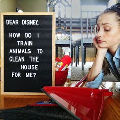 a woman sitting at a table next to a sign that says dear disney, how do i train animals to clean the house for me?