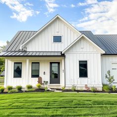 a white house sitting on top of a lush green field