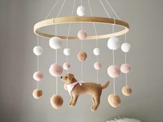 a stuffed dog is hanging from a wooden mobile with balls on it's sides