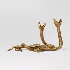 a gold snake figurine on a white background